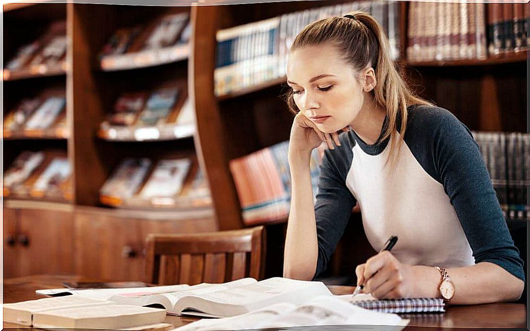 Young blonde girl studying in the library.