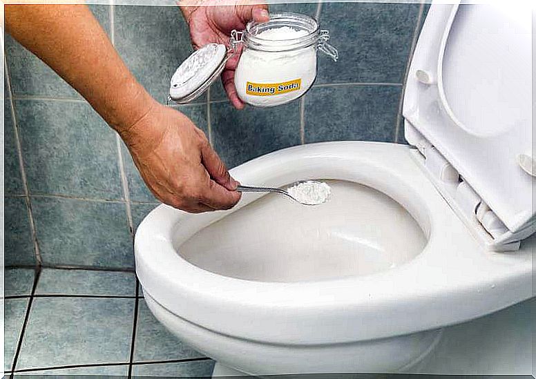 Man cleaning a toilet with baking soda