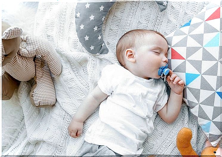 Baby sleeping with his stuffed animals and pacifier.