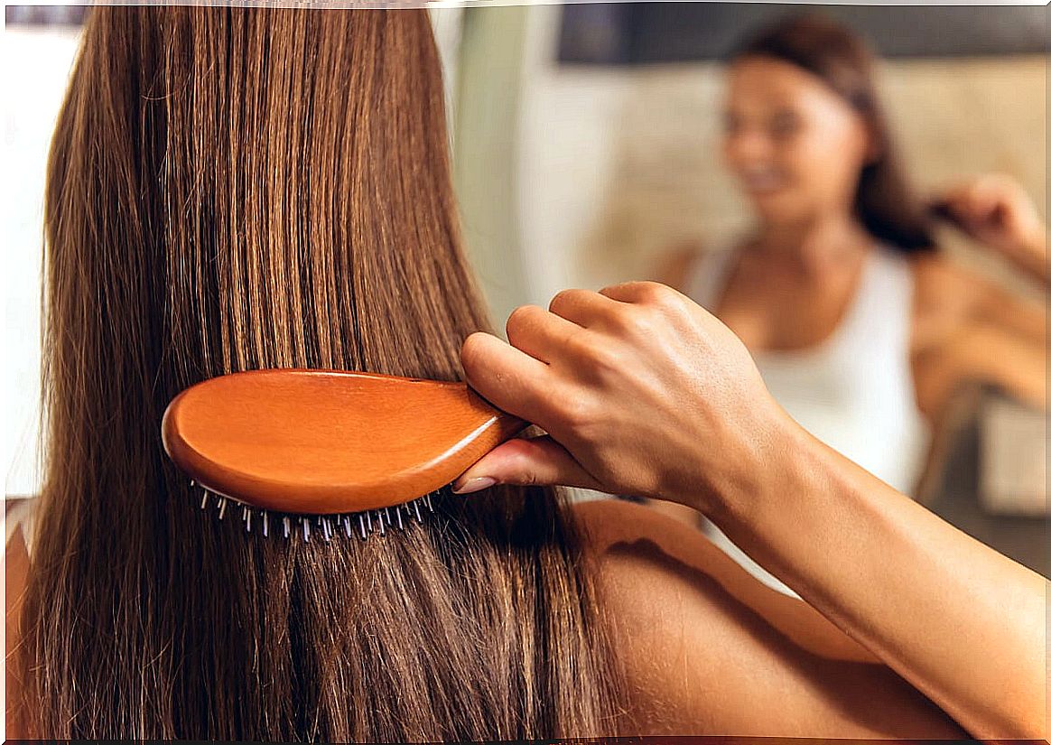 Woman brushes her hair.