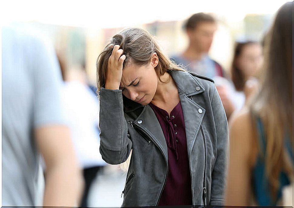 Woman on the street with hand on head