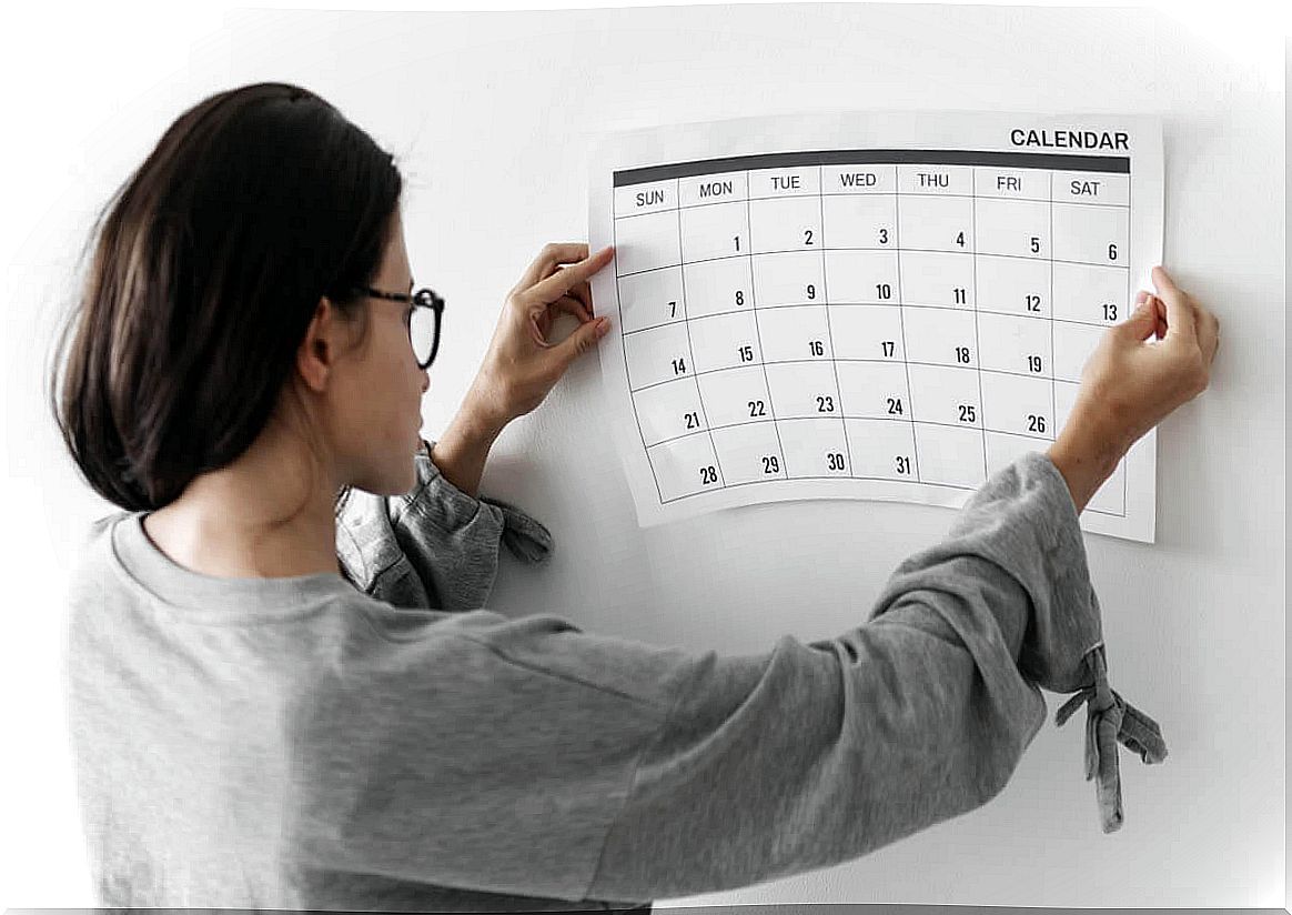 Woman placing a calendar on the wall