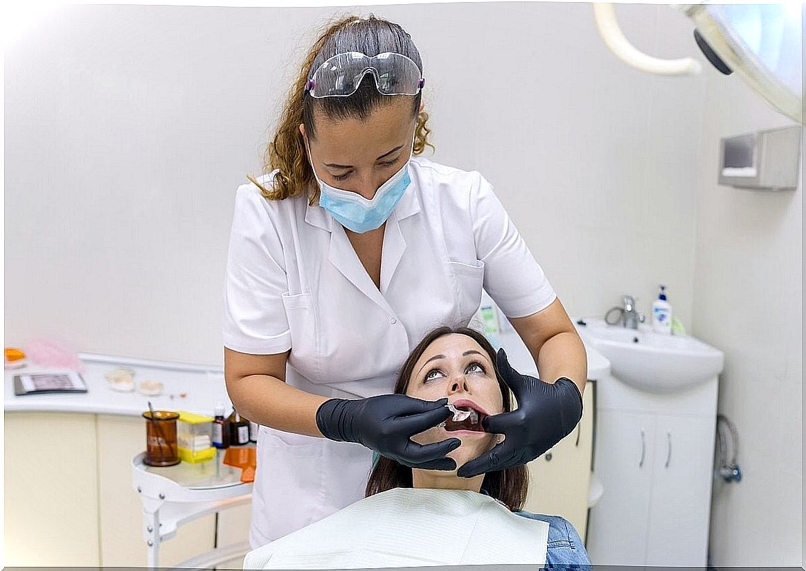 Dentist places dental piercing.